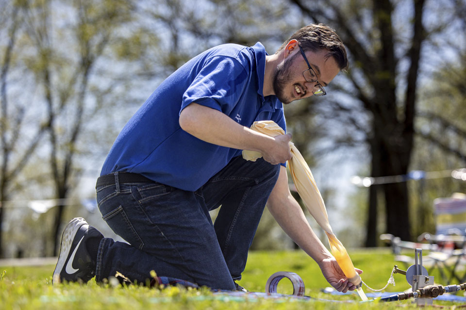 Riley Jackson inflates a weather balloon during the solar eclipse at Trail of Tears State Park on April 8, 2024. Photo by Sarah Conroy. 