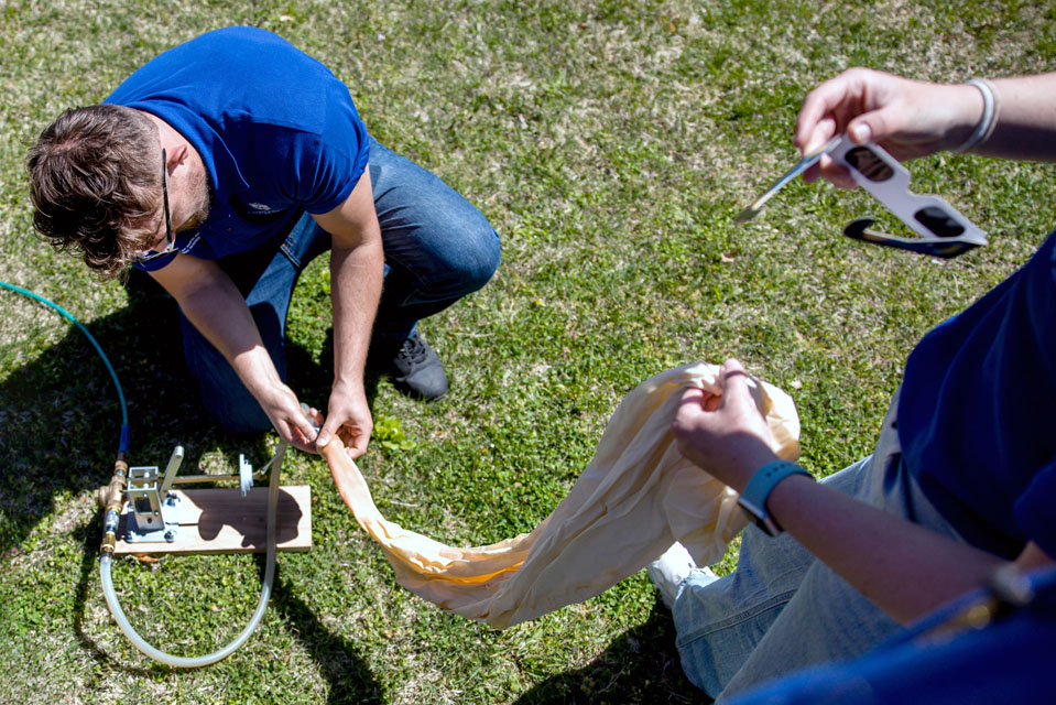 Benjamin Schaefer inflates a weather balloon during the solar eclipse at Trail of Tears State Park. Photo by Sarah Conroy. 