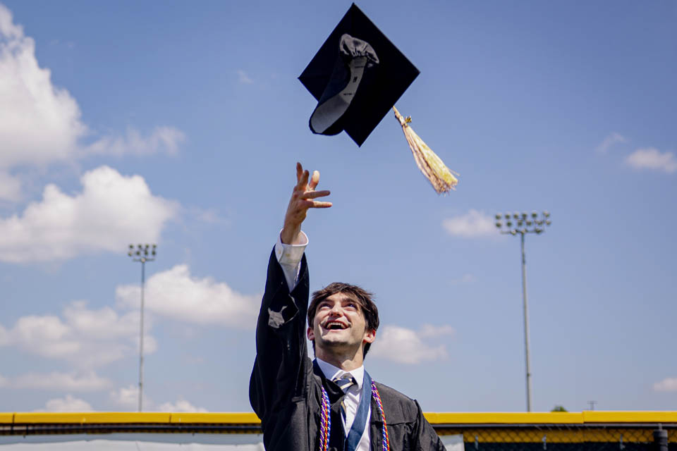 A graduate tosses his cap after Commencement on May 18, 2024. Photo by Sarah Conroy. 