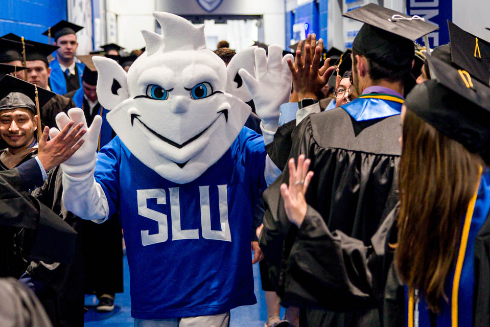 The Billiken high-fives graduates before Commencement on May 18, 2024. Photo by Sarah Conroy. 