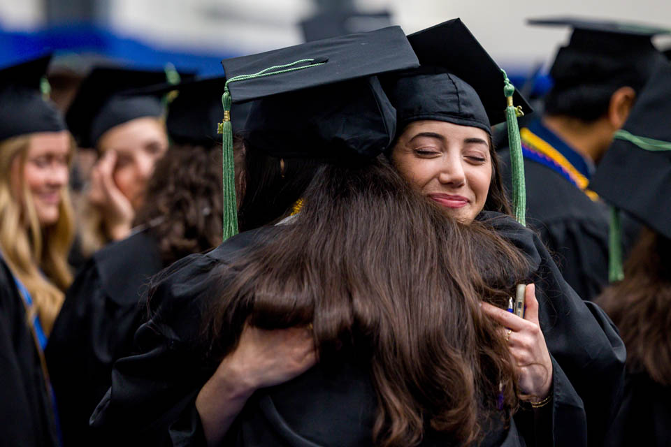 Graduates hug before Commencement on May 18, 2024. Photo by Sarah Conroy. 