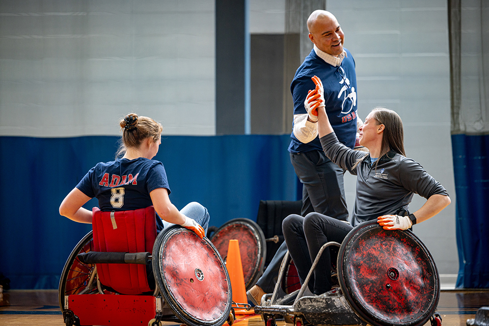 Bernard Rousseau, Ph.D., dean of Doisy College of Health Sciences, supports Sarah Adam with a high five during DASA (Disabled Athlete Sports Association) Day on April 22, 2024. Photo by Sarah Adam. 