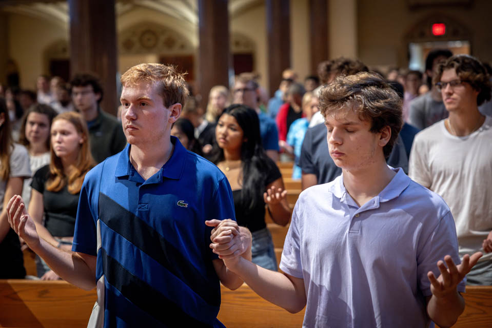 Students pray the Our Father during the Mass of the Holy Spirit at St. Francis Xavier College Church on Aug. 22, 2024. Photo by Sarah Conroy.