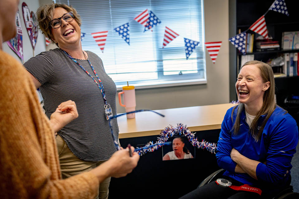 Sarah Adam, OTD, assistant professor of occupational science and occupational therapy, shows her Paralympic silver medal on her first day back to campus on Monday, Sept. 9, 2024. Adam made history as the first woman to represent the US Wheelchair Rugby team in the Paralympics and won a silver medal. Photo by Sarah Conroy.