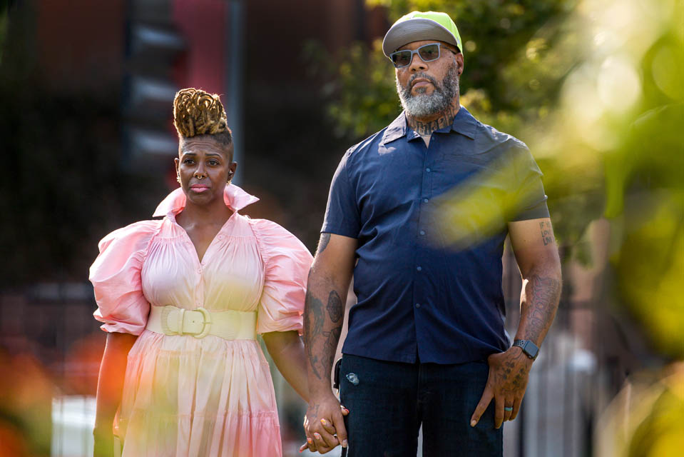 Artist Cbabi Bayoc, right, and his wife, Amber, listen to Malaika Horne, Ph.D,  a former Mill Creek community member during the celebration for Bayoc’s “The Legacy of Mill Creek,” an art installation surrounding the fountain at Grand and Lindell Blvds. The installation honors the vibrant historically Black community that lived in the former Mill Creek Valley neighborhood. Photo by Sarah Conroy. 