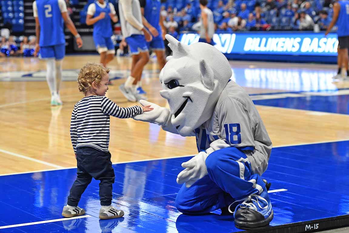 The Billiken poses with a small 2024 Homecoming and Family Weekend fan.