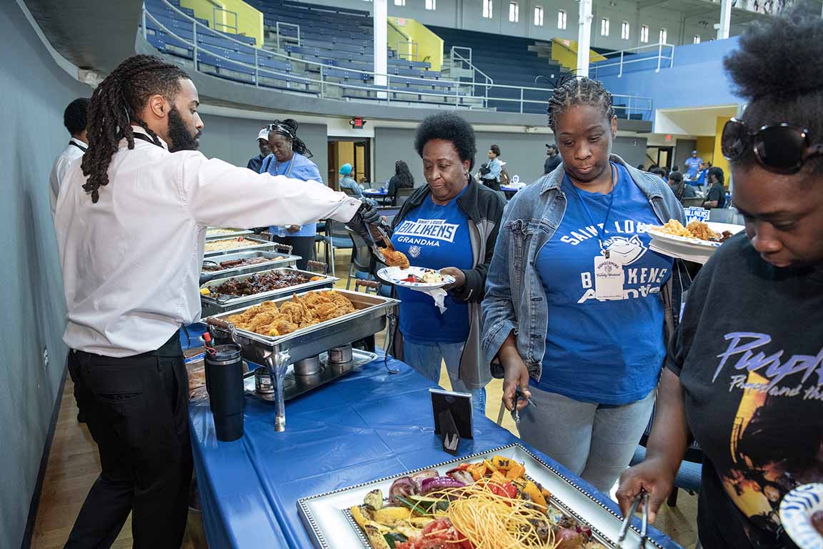Attendees at SLU's 2024 BAA Family reunion go through a buffet line. 