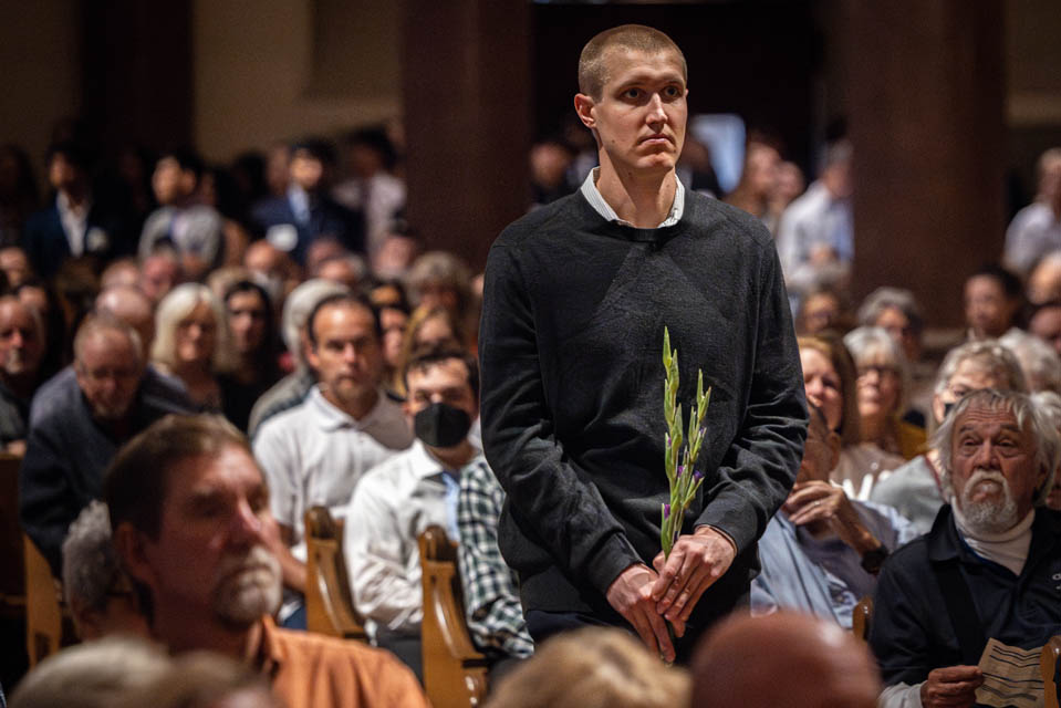 A Medical student carries flowers to the altar during the Interfaith Memorial Service for the Gift Body Program on Friday, Oct. 25, 2024. Photo by Sarah Conroy. 