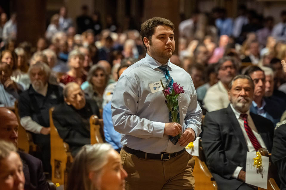 A Medical student carries flowers to the altar during the Interfaith Memorial Service for the Gift Body Program on Friday, Oct. 25, 2024. Photo by Sarah Conroy. 