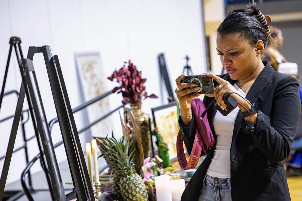 An attendee takes photos of the display of personal items during the Lights of Remembrance Candlelight Vigil on Thursday, Feb. 27, 2025. Photo by Sarah Conroy. 