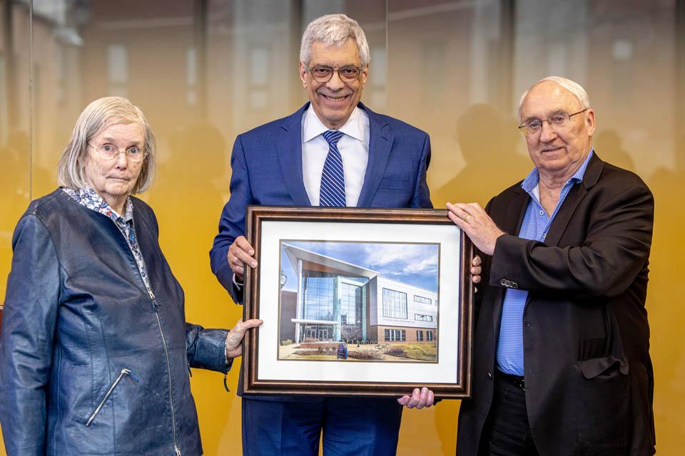 Dr. Jeanne and Rex Sinquefield are presented with a photo by Fred P. Pestello, Ph.D., during the dedication of the Sinquefield Science and Engineering Center on March 18, 2025. Photo by Sarah Conroy. 
