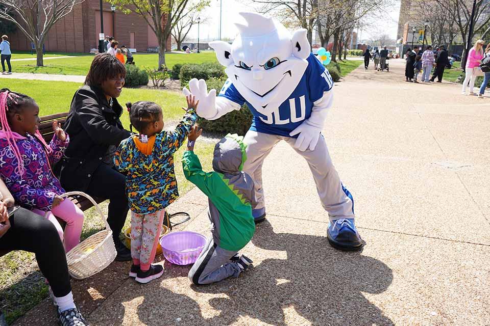 The Billiken visits with families during the Easter Egg Hunt.