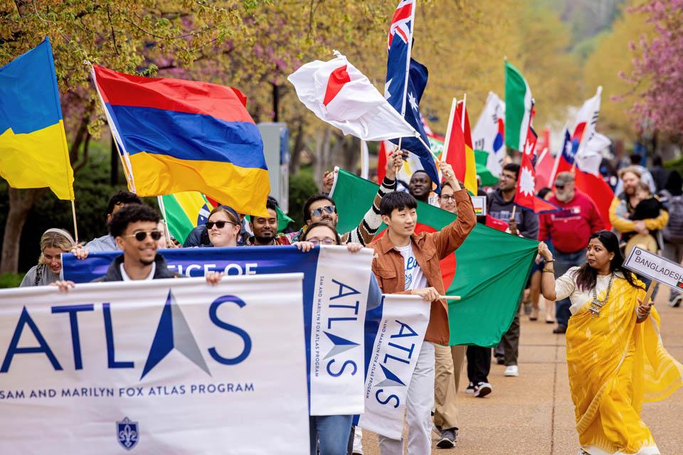 Members of the SLU community carry flags representing their countries during the Atlas Week Parade of Nations on April 11, 2025. Photo by Sarah Conroy.  
