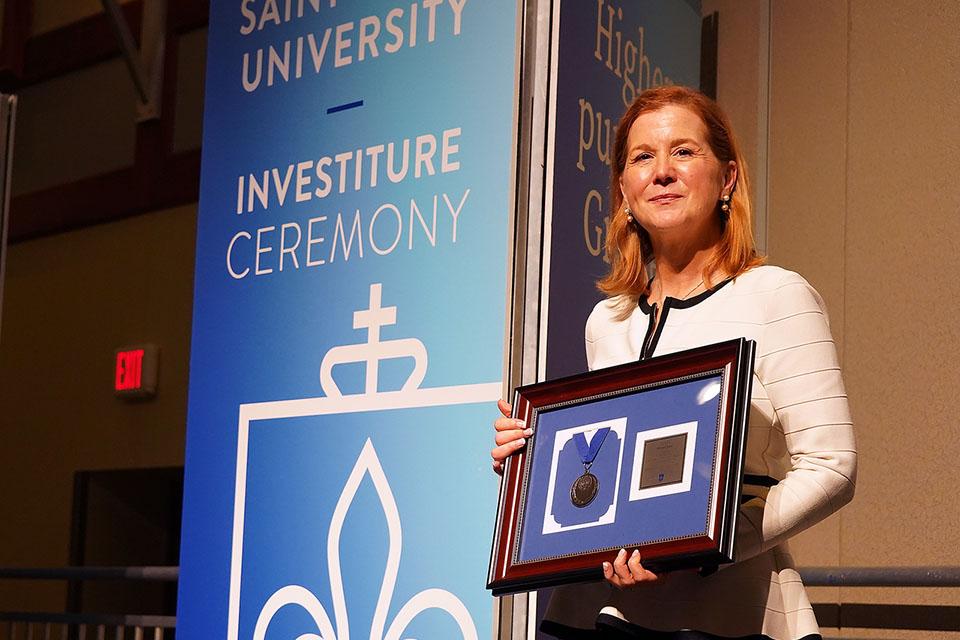 An honoree receives recognition on stage at the Investiture Ceremony. 
