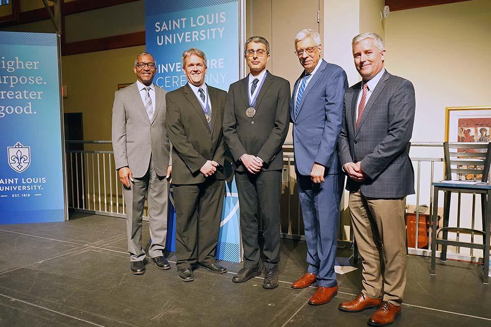 An honoree receives recognition on stage at the Investiture Ceremony. 