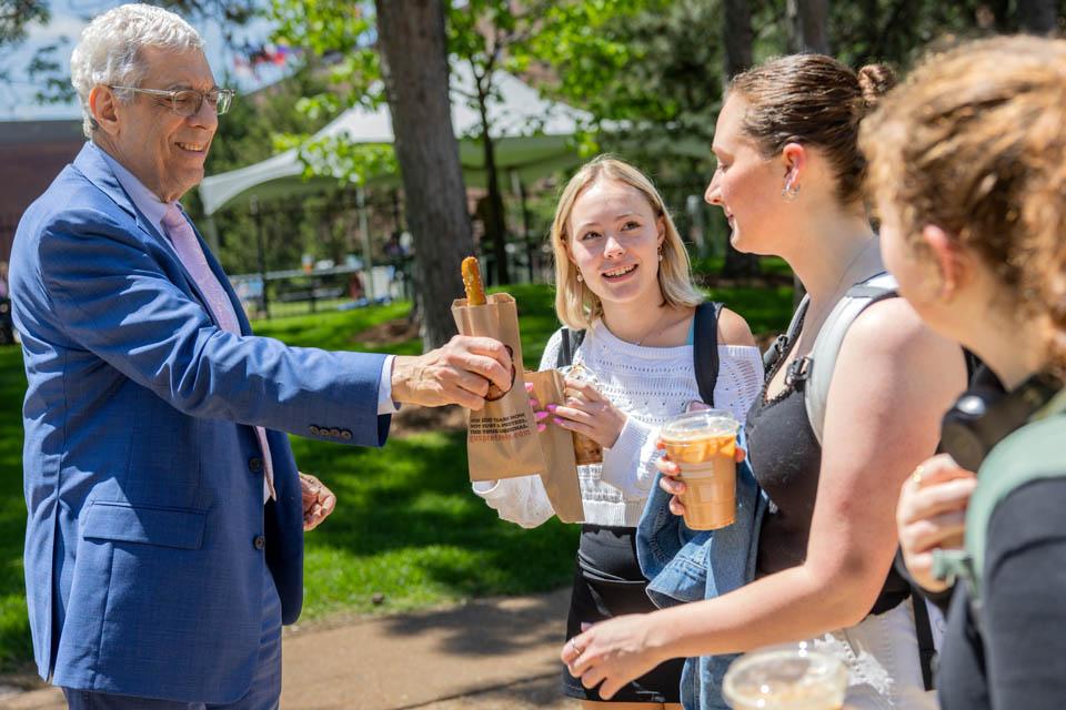 President Fred P. Pestello, Ph.D., passes out pretzels to students before the start of final exams on May 6, 2025. Photo by Sarah Conroy.