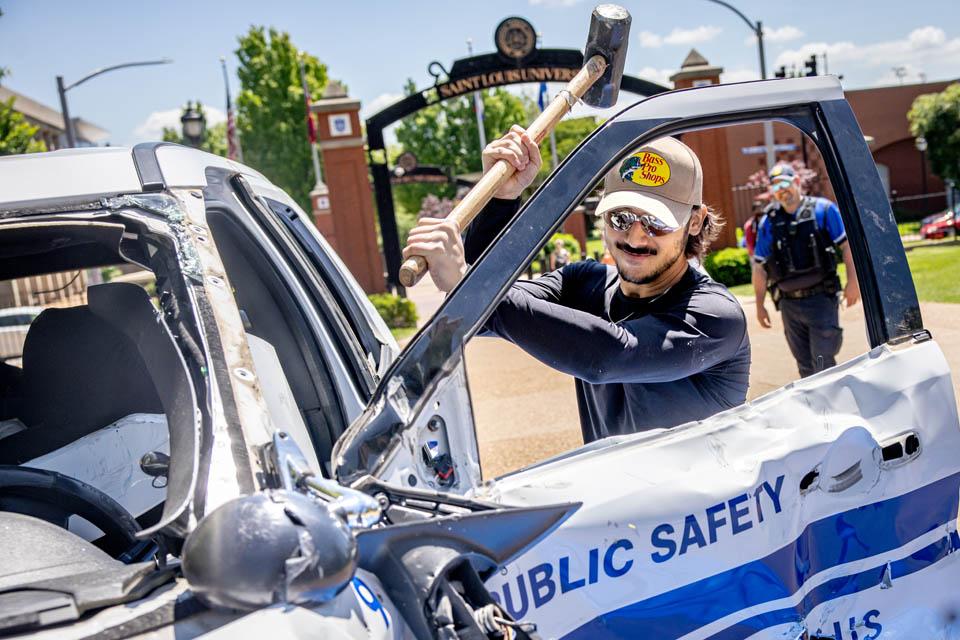 Students hit an old Public Safety car during the Destress with DPS event on May 6, 2025. Photo by Sarah Conroy. 