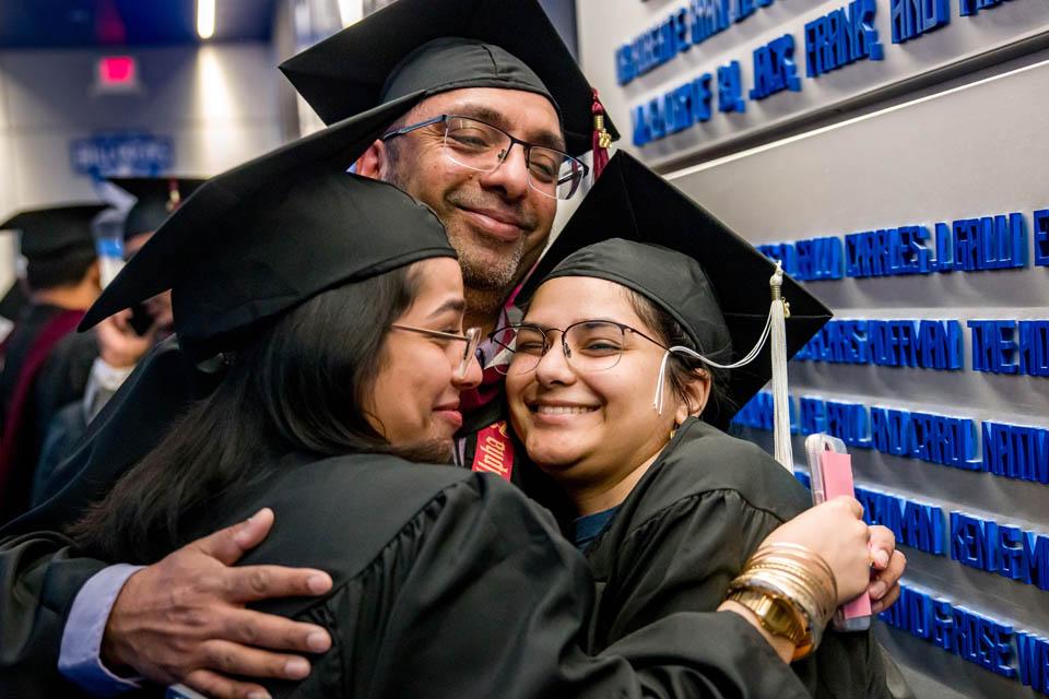 Graduates embrace before Commencement at Chaifetz Arena on May 17, 2025. Photo by Sarah Conroy.