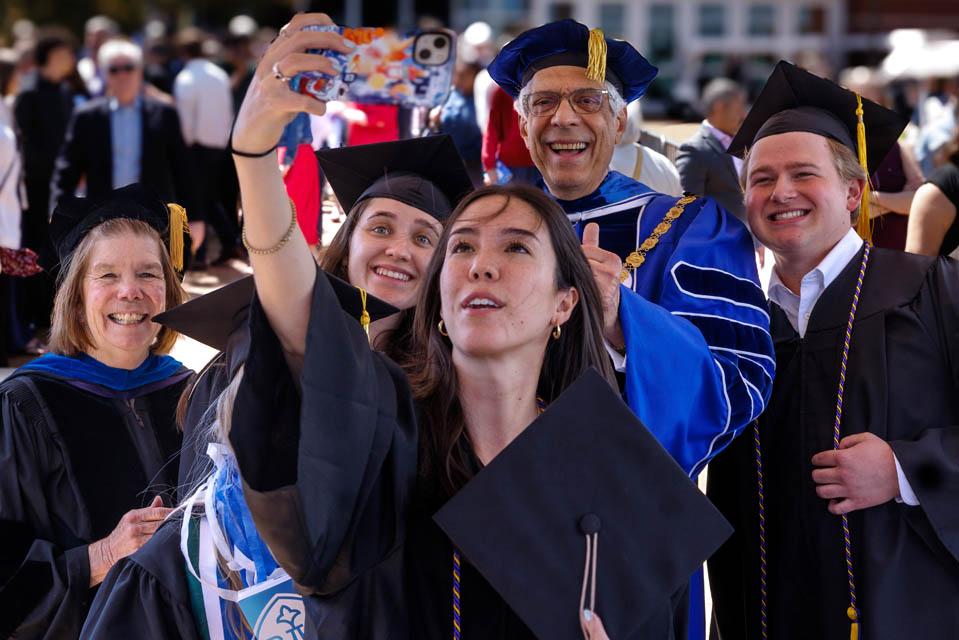 President Fred P. Pestello, Ph.D., and First Lady Fran Pestello, Ph.D. take a selfie with graduates after Commencement on May 17, 2025. Photo by Sarah Conroy.
