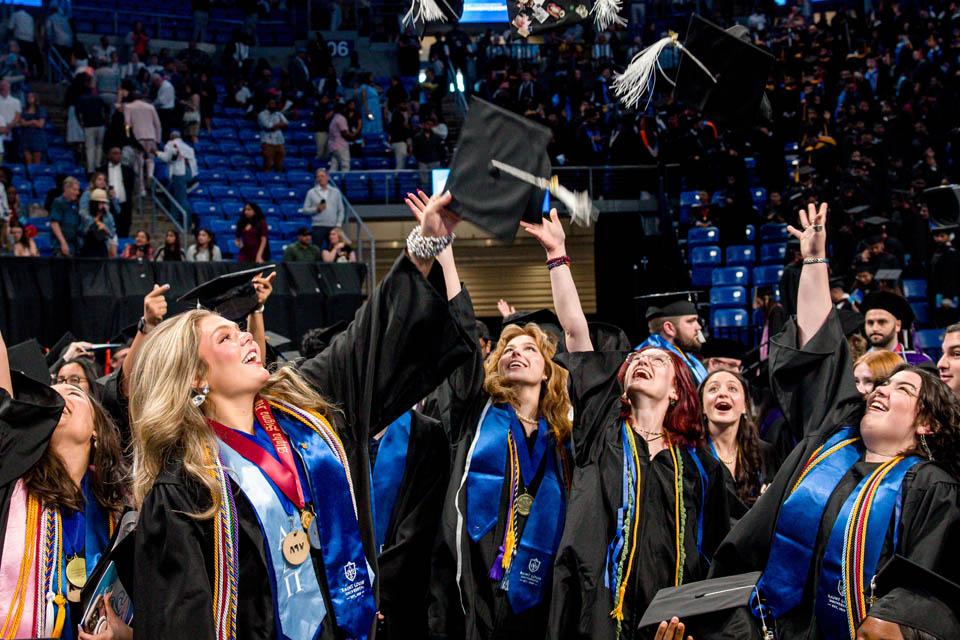 Graduates toss their caps after Commencement on May 17, 2025. Photo by Sarah Conroy.