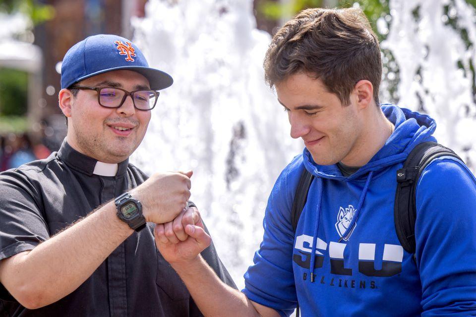 SLU students talk to a priest during a vocation fair on campus April 25. Photo by Sarah Conroy.