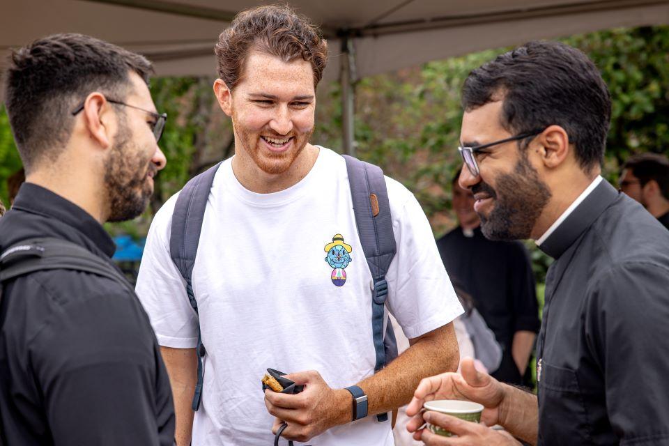 A SLU student talks to priests during a vocation fair on campus April 25. Photo by Sarah Conroy.