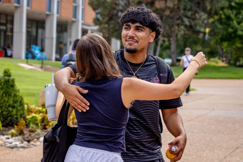 Two students hug. 