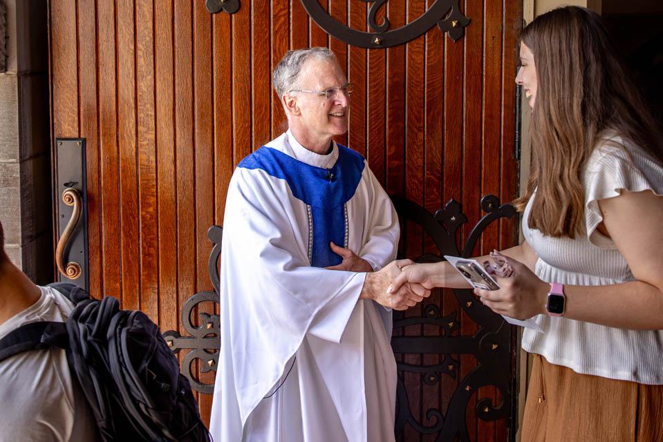 Very Rev. Thomas P. Greene, S.J., shakes hands with students.