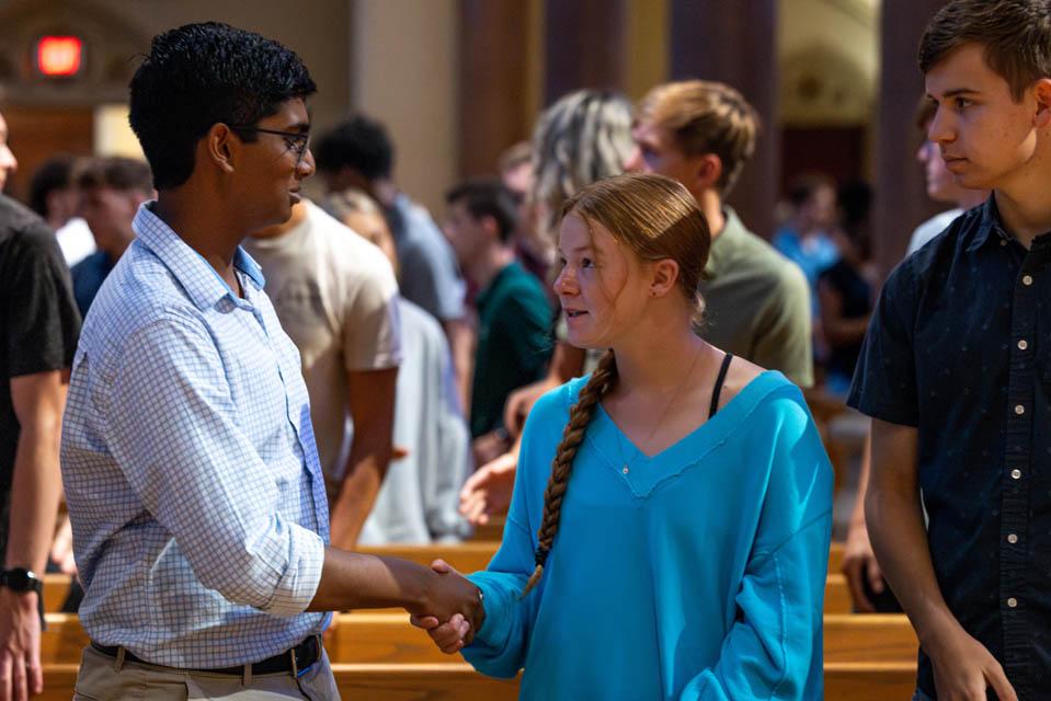 Students shake hands. 