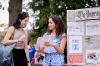 Two students outside at SLU discuss a club.  
