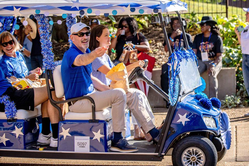 President Edward Feser, Ph.D., tosses candy during the Homecoming and Family Weekend Golf Cart Parade on Sept. 27, 2025. Photo by Sarah Conroy. 