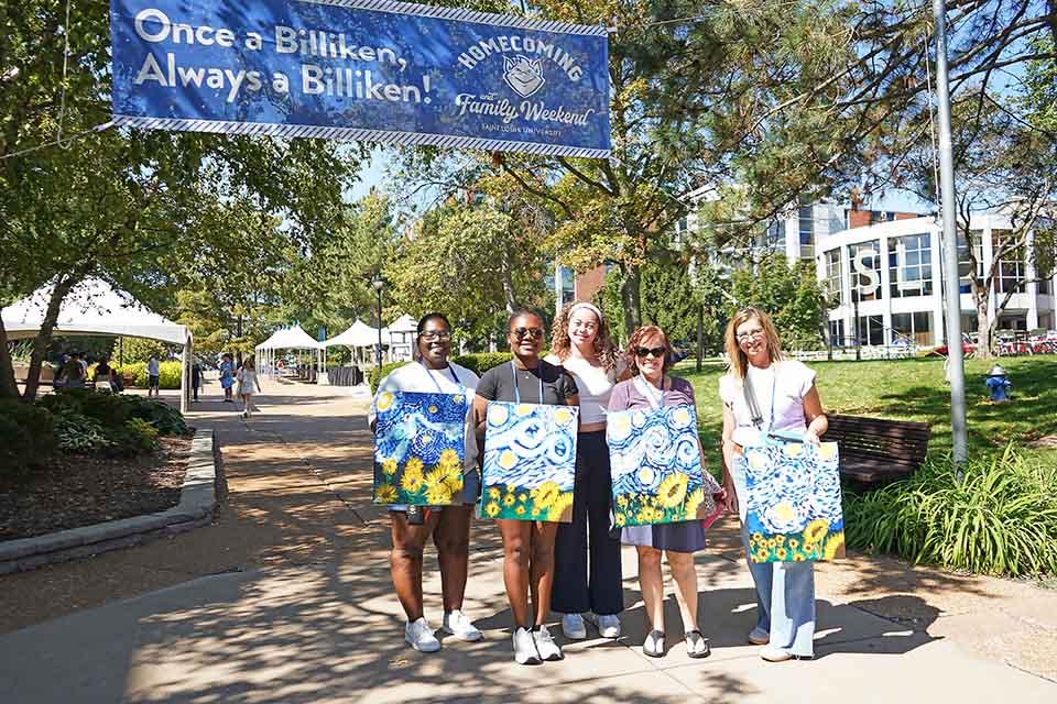 Homecoming and Family Weekend attendees show off their works of art from paint and sip. Photo by Megan Favignano Mansouri.