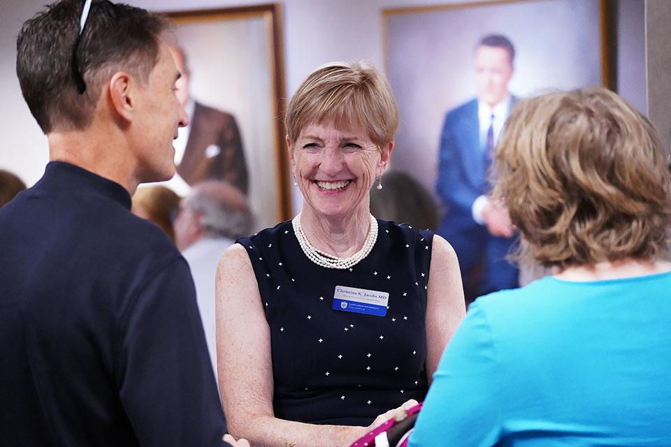 Christine Jacobs, M.D., dean and vice president of medical affairs, speaks with alumni at a reception inside the School of Medicine during  SLU's 2025 Med Reunion. Photo by Megan Favignano Mansouri.