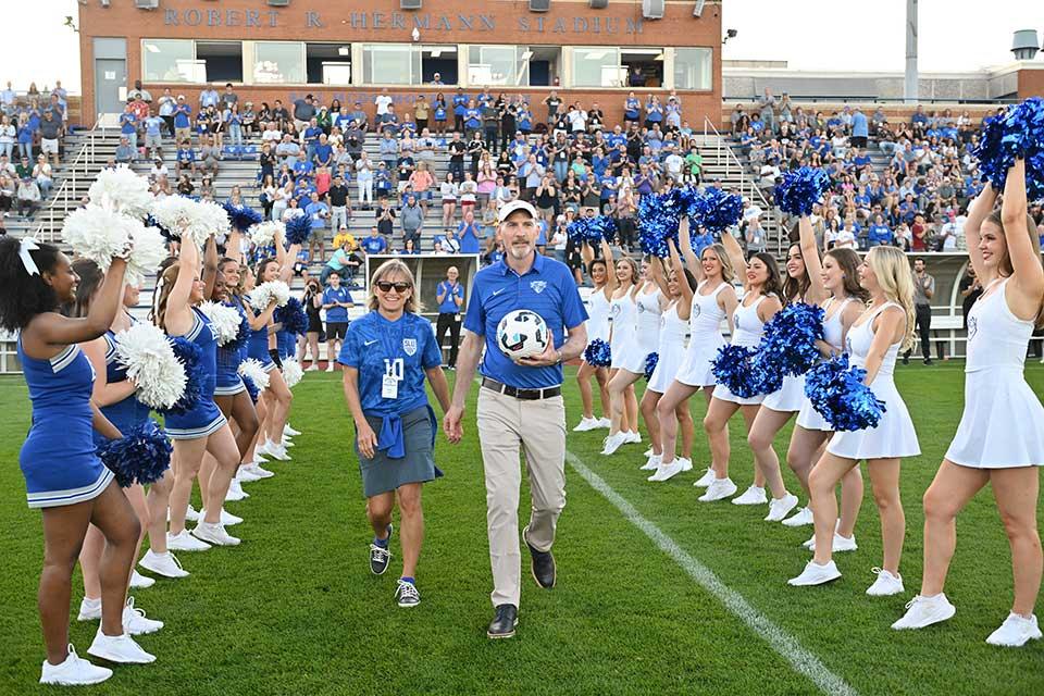 President Feser and Kathy Feser present the game ball at the Billiken homecoming soccer game on Sept. 27, 2025.
