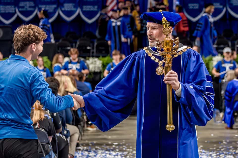 SLU President Edward Feser, Ph.D. greets an attendee at the Nov. 5, 2025, inauguration ceremony. Photo by Sarah Conroy.