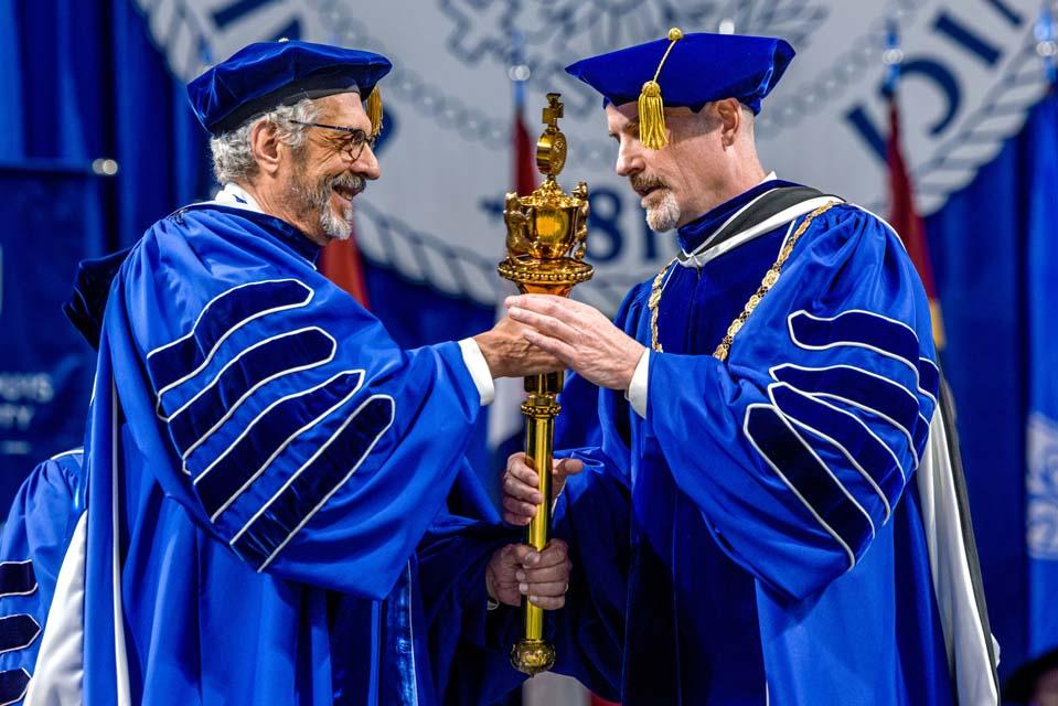 President Emeritus Fred P. Pestello, Ph.D., left, hands the University mace to new President Edward Feser, Ph.D., SLU's inauguration ceremony on Wednesday, Nov. 5, 2025. Photo by Sarah Conroy.