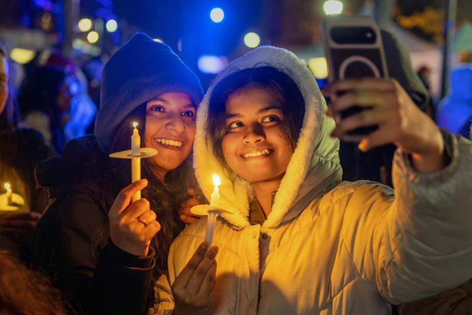 Students take a selfie with their candles during Christmas on the Quad on Dec. 6, 2025. Photo by Sarah Conroy.