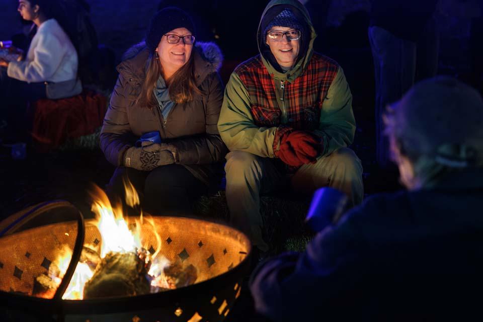 Attendees chat by the fire pits during Christmas on the Quad on Dec. 6, 2025. Photo by Sarah Conroy.