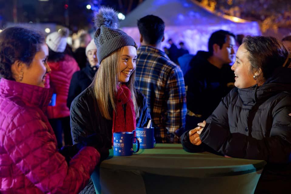 Students chat and drink hot chocolate during Christmas on the Quad on Dec. 6, 2025. Photo by Sarah Conroy.