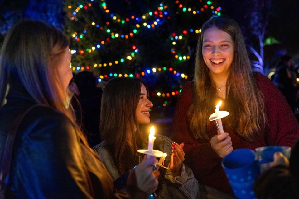 Students chat near the newly lit Christmas tree during Christmas on the Quad on Dec. 6, 2025. Photo by Sarah Conroy.