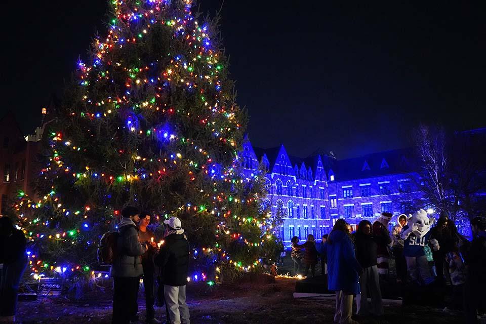 Attendees gather around the Billiken near the tree during Christmas on the Quad on Dec. 6, 2025. Photo by Megan Favignano Mansouri.