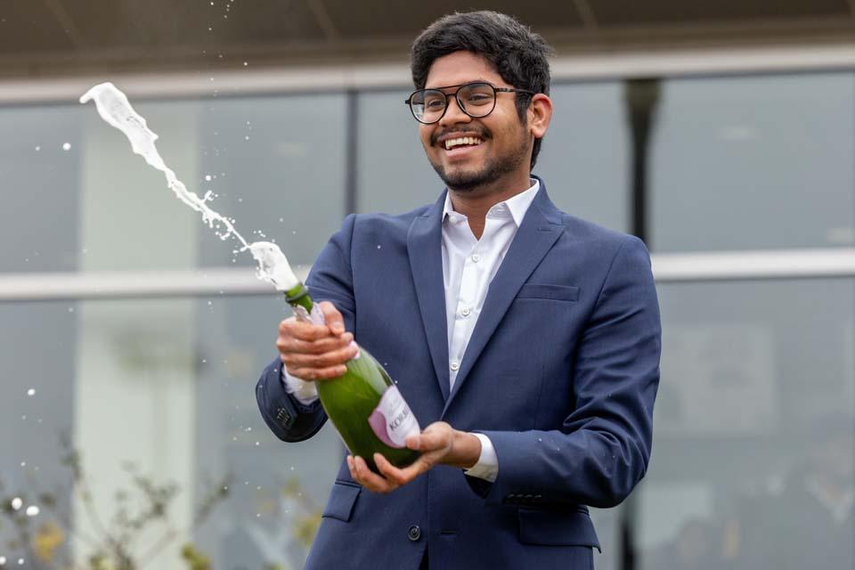 A graduate celebrates with champagne after Midyear Commencement on Dec. 13, 2025. Photo by Sarah Conroy.