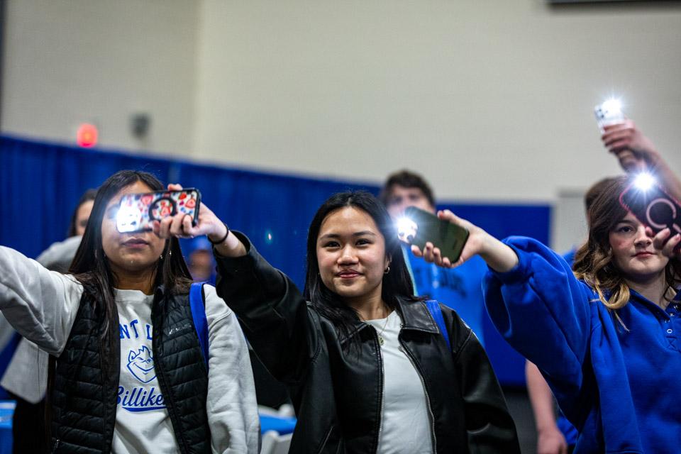 Admitted students wave their mobile flash lights as they learn SLU cheers.
