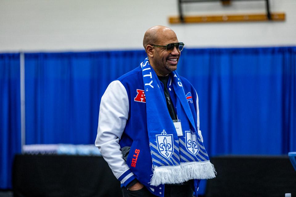 An admitted student's parent stands and learns SLU cheers.