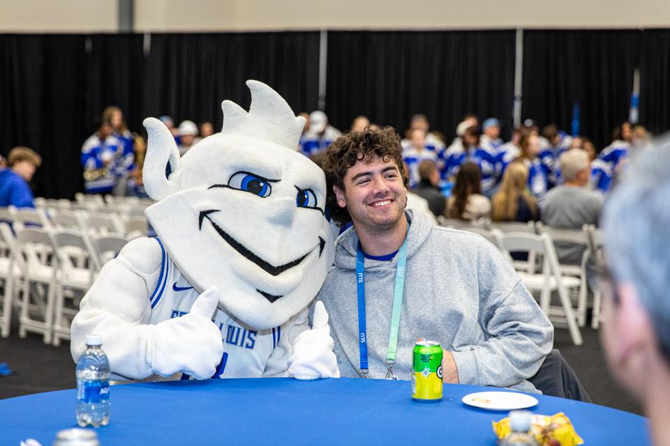 An admitted student poses with the Billiken at the pre-game party for the men's basketball game vs. La Salle.