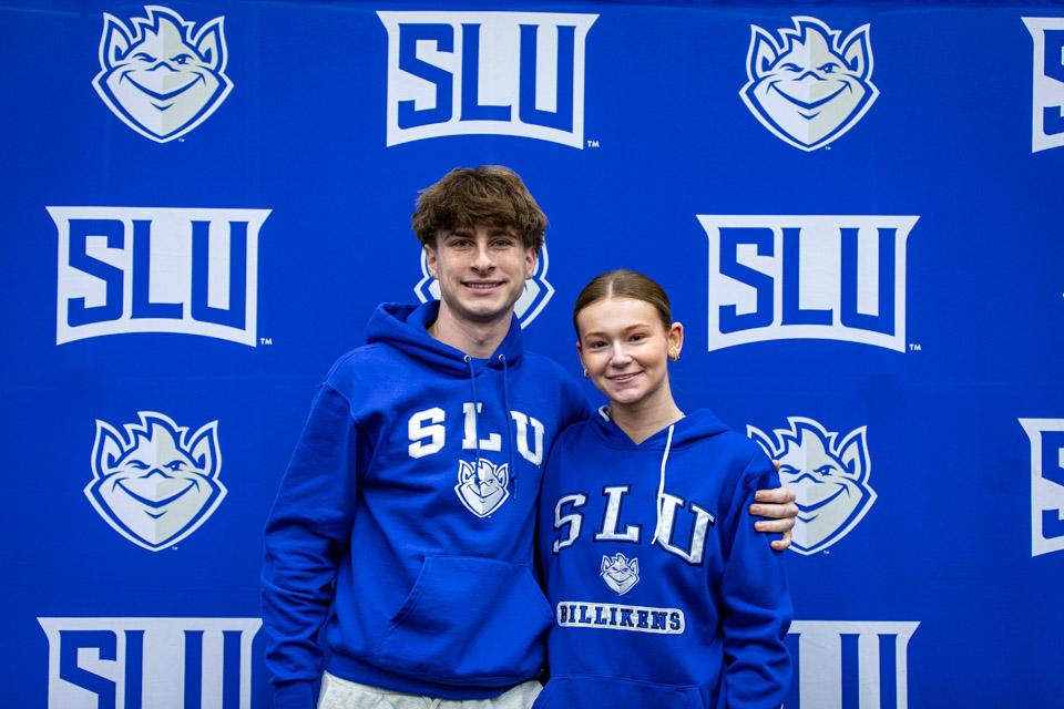 Two admitted students poses at the athletics backdrop before the men's basketball game vs. LaSalle.