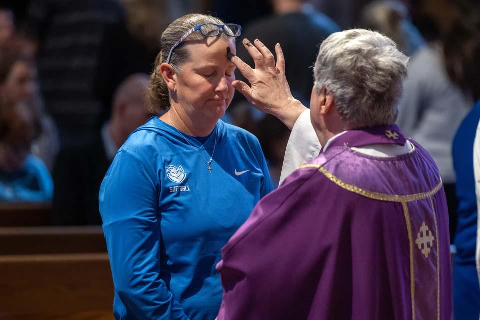 Softball head coach Christy Connoyer receives ashes during Ash Wednesday Mass on Feb. 18, 2026. Photo by Sarah Conroy.

