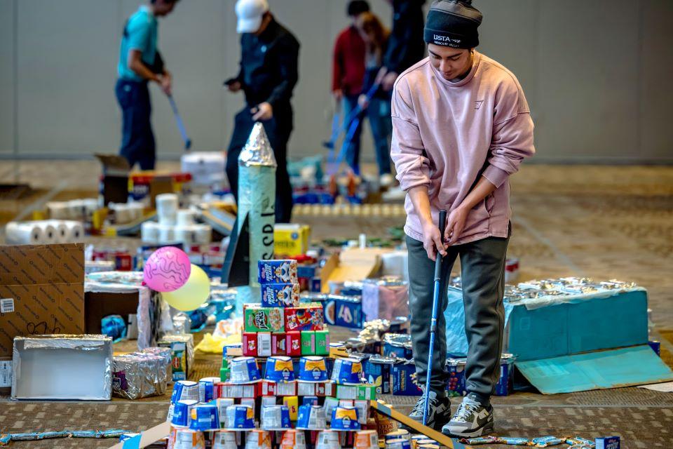 Members of the SLU community play miniature golf on a course constructed from shelf-stable grocery items at Golf and Give, an Innovation Challenge to benefit Billiken Bounty, on February 24, 2026. Photo by Sarah Conroy.