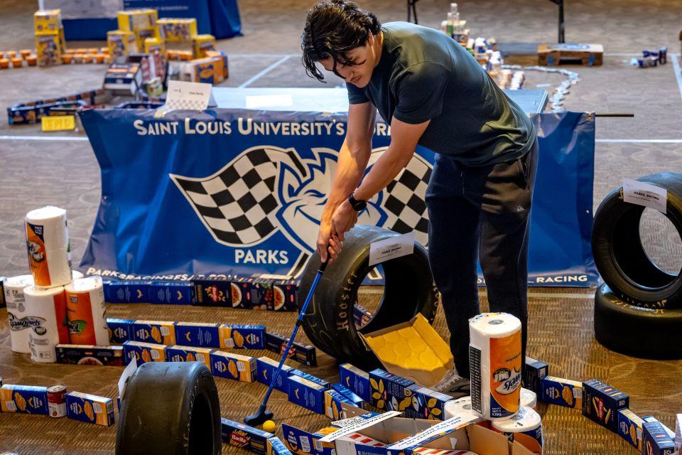 Members of the SLU community play miniature golf on a course constructed from shelf-stable grocery items at Golf and Give, an Innovation Challenge to benefit Billiken Bounty, on February 24, 2026. Photo by Sarah Conroy.