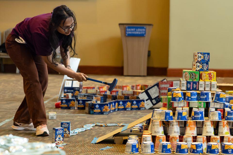 Members of the SLU community play miniature golf on a course constructed from shelf-stable grocery items at Golf and Give, an Innovation Challenge to benefit Billiken Bounty, on February 24, 2026. Photo by Sarah Conroy.